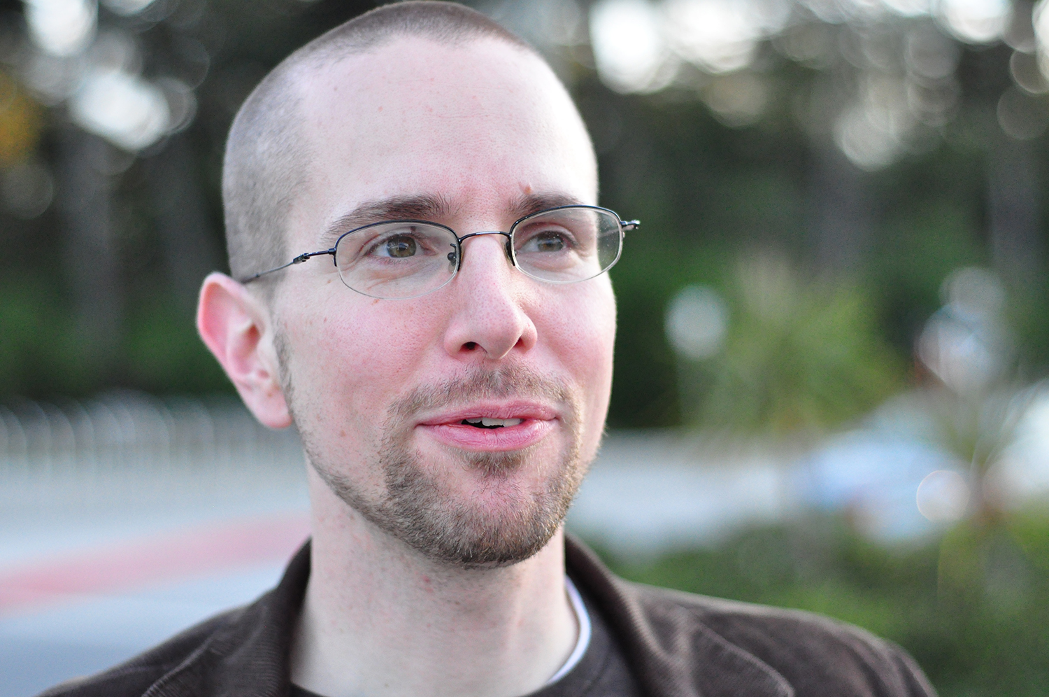 This is a photo of Dan Bouk, with a closely cropped haircut, wire-frame glasses, pale skin, a short beard and mustache, and wearing a brown corduroy blazer.